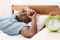 A young man lying awake in bed unable to go to sleep