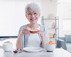 Older woman eating more comfortably with dental bridge 