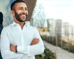 A young man standing outside and smiling