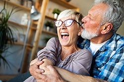 older couple laughing while holding each other 