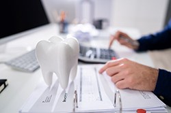 patient calculating cost of tooth extraction 