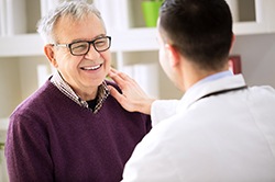 Man smiling at his Weyauwega implant dentist after treatment