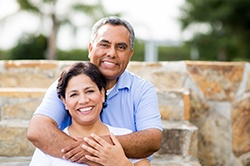 Smiling couple outdoors with dental implants in Weyauwega