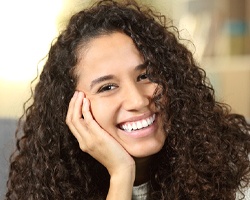 A young female smiling and showing off her healthier teeth after seeing her holistic dentist in Weyauwega, WI