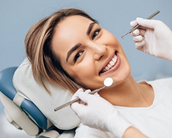 A young female patient lying in a dentist’s chair preparing to have her teeth checked