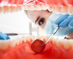 A woman performing a dental exam.