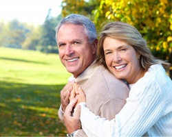 An older couple smiling outside.