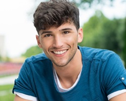 A young teen smiling outside.