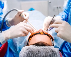 Two dental professionals performing dental work on a patient and preparing to use PRF/PRP