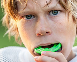 Teen boy placing sports mouthguard