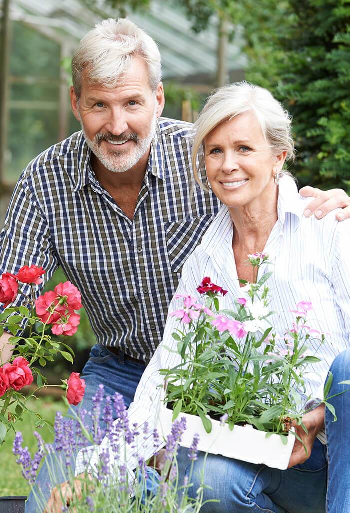 Smiling senior man and woman gardening outdoors