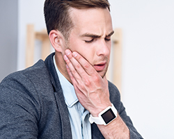 Man holding jaw in pain