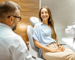 A young female seated in the dentist’s chair while listening to her holistic dentist in Weyauwega, WI