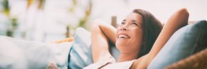 a middle-aged woman lying back on a chair and smiling after having ozone therapy