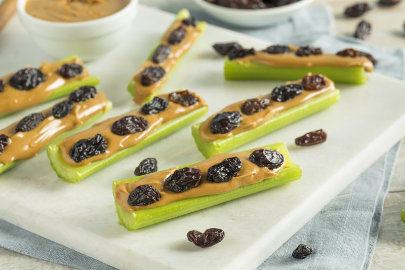 a plate full of celery filled with peanut butter and raisins