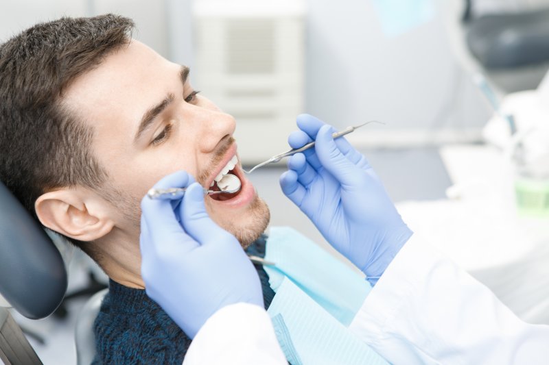 a young man having his teeth checked by a trusted dentist