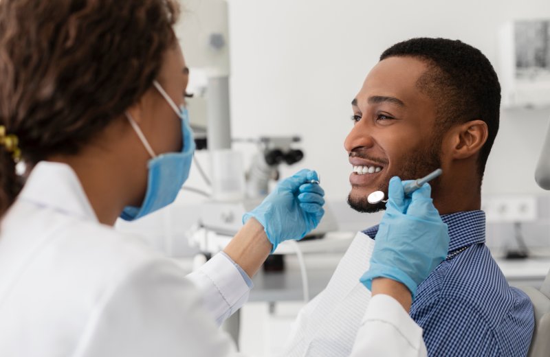 a patient smiling while his dentist works on him
