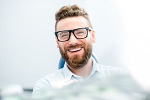 Smiling male dental patient with glasses