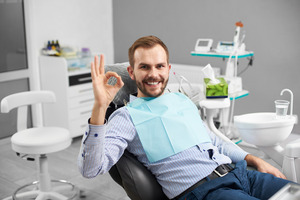 Smiling male patient giving the “okay” sign